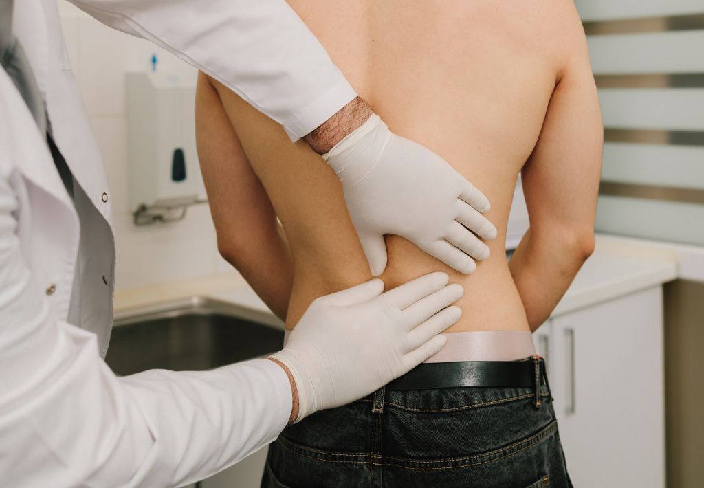 a lower back is being examined by a doctor as they determine the best spot for an incision for hormone pellet therapy pittsburgh.