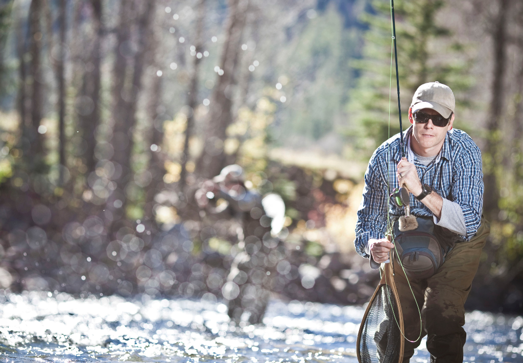 a coulple of guys are ankle deep in a flowing stream reeling in some fish. Indiana functional medicine has them feeling strong and ready for outdoor adventure.